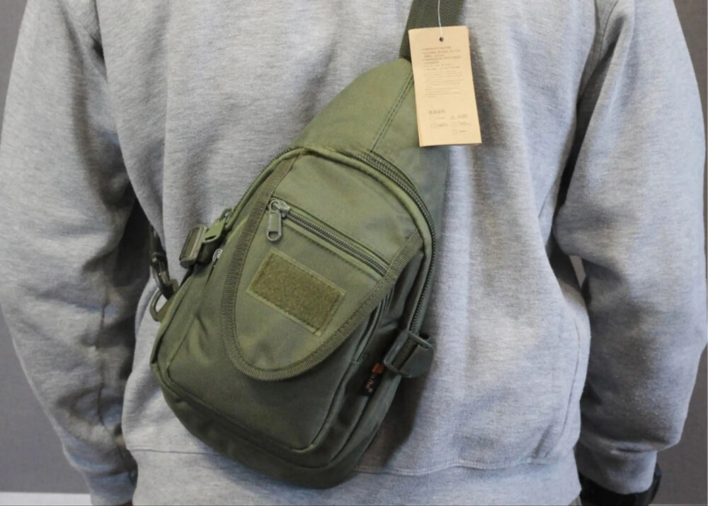 Saszetka EXTRALINK MIL-1119 Zielony osoba w szarej bluzie ma założoną saszetkę na plecach organizacja wyposażenia praktyczna porządek przechowywanie