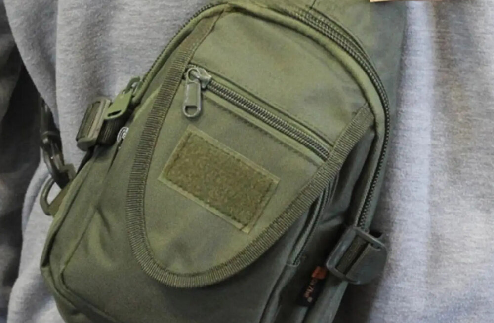 Saszetka EXTRALINK MIL-1119 Zielony osoba w szelka bluzie ma założoną saszetkę na plecach taśmy MOLLE umożliwiają rozbudowę saszetki o dodatkowe pokrowce lub wyposażenie taktyczne funkcjonalność można dopasować ją do indywidualnych potrzeb użytkownika