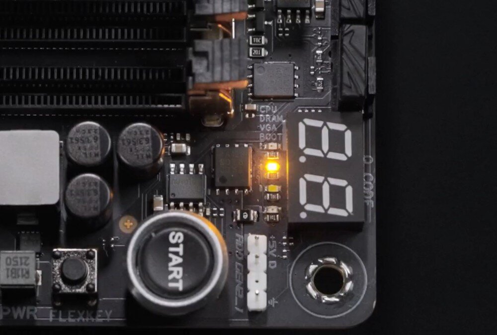 Płyta główna ASUS ROG Strix X870E-E Gaming WiFi Zbliżenie na róg płyty głównej z przyciskiem 'Start', wyświetlaczem diagnostycznym POST i podświetloną kontrolką błędu, uproszczony montaż, rozwiązania