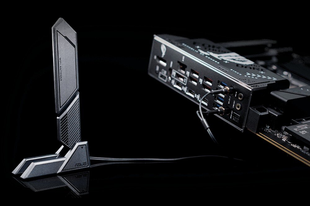 Płyta główna ASUS ROG Strix X870-F Gaming WiFi Czarna antena WiFi stojąca obok panelu portów płyty głównej z podłączonymi przewodami, łączność Wi-Fi 7, pasmo 6 GHz, karta sieciowa