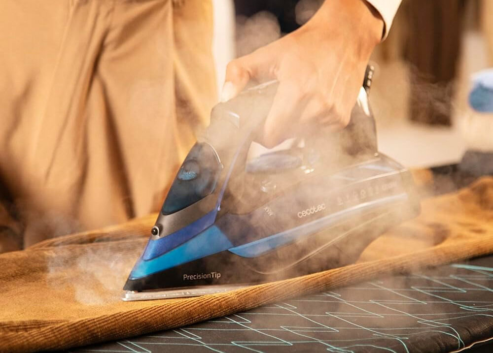 Żelazko CECOTEC IronHero 3200 I-Pump Anodized osoba trzyma żelazko prasowanie materiału wydostająca się para technologia Power Steam imponujący wyrzut pary do 75 g/min szybkie dokładne prasowanie para wnika w głąb włókien ułatwienie procesu prasowania funkcja stałego wyrzutu pary zwiększa efektywność minimalizuje konieczność kilkukrotnego prasowania zbiornik na wodę o pojemności 380 ml komfort użytkowania