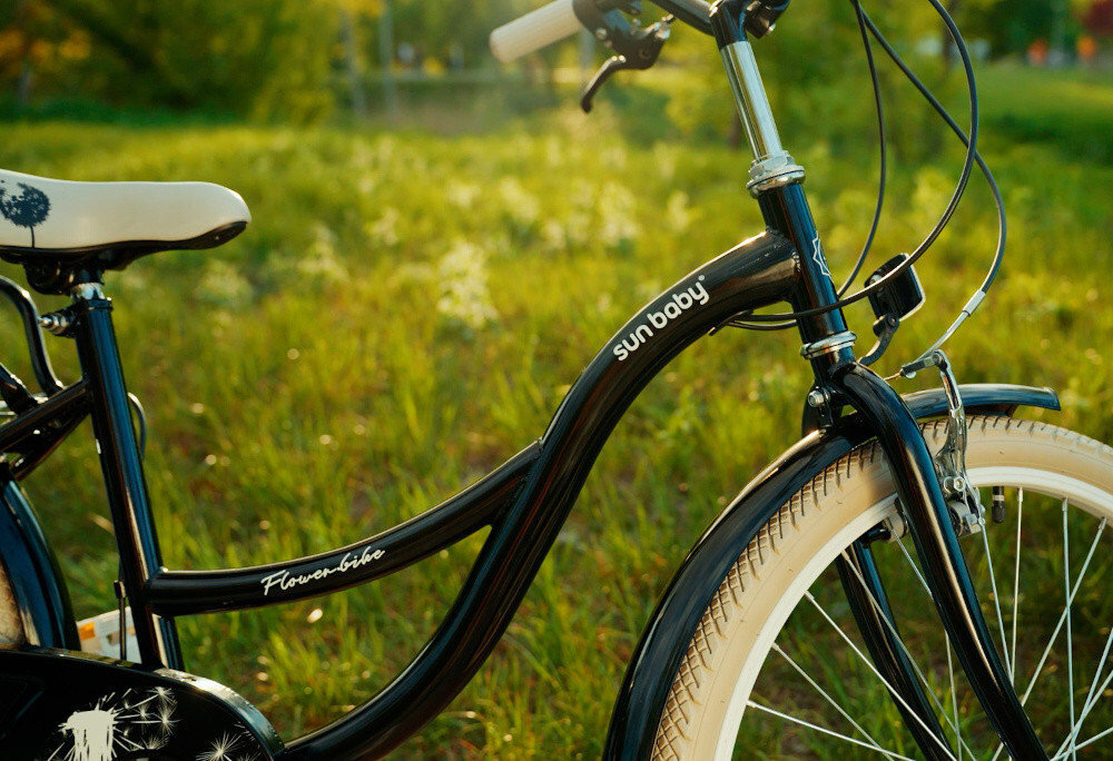 Rower młodzieżowy SUN BABY Flower Bike 24 cale dla dziewczynki Czarny zbliżenie na ramę w tle trawa i drzewa odpowiednio wyselekcjonowane materiały stalowa 14,5-calowa rama dostosowana do najmłodszych geometria ponadprzeciętna odporność na uszkodzenia mechaniczne i działanie czynników zewnętrznych  wybór rozmiaru ramy Twój wzrost mierzony w zrelaksowanej pozycji typ roweru