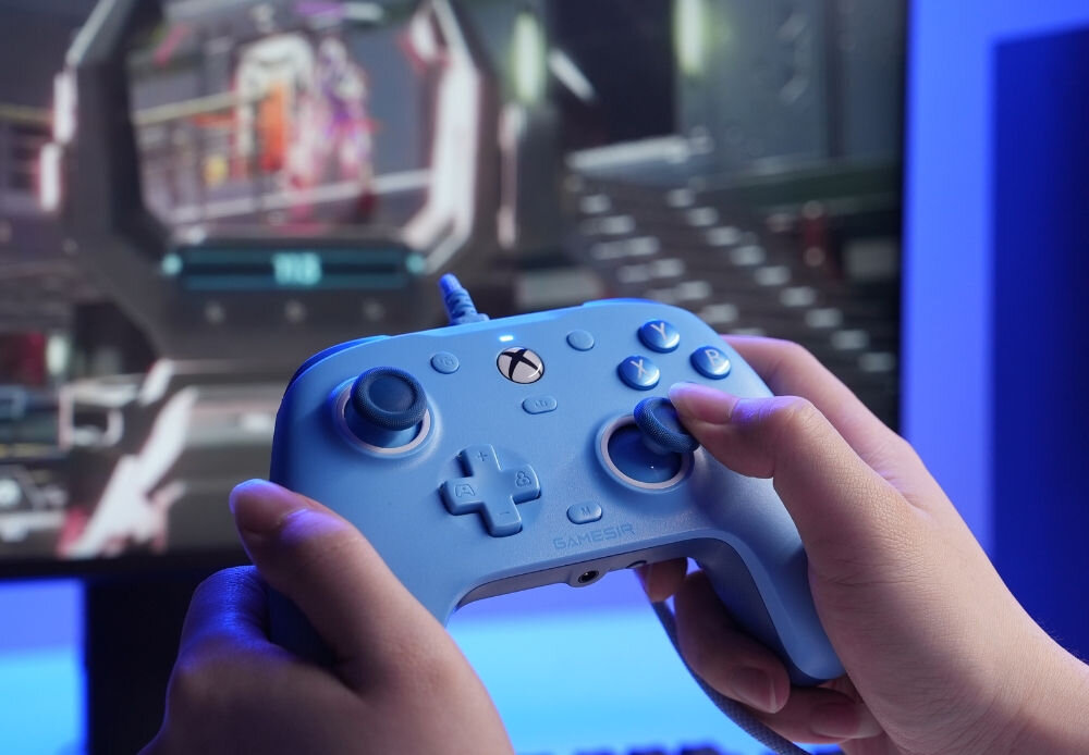 Kontroler GAMESIR G7 SE Niebieski
                w dłoniach na tle monitora xbox pc drążki hall effect długotrwała dokładność ergonomiczny układ przycisków