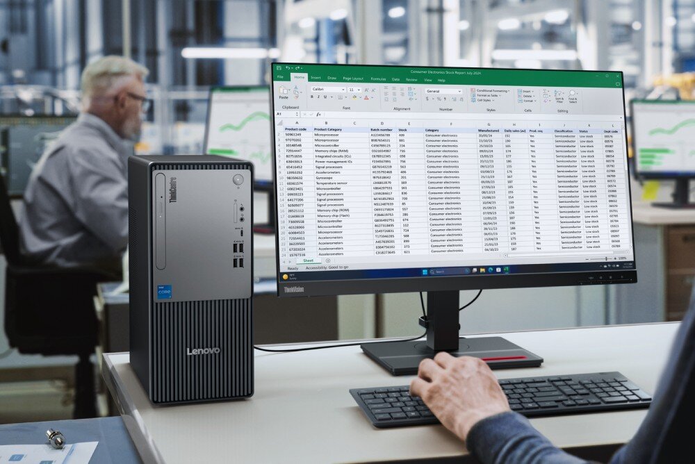 Komputer LENOVO ThinkCentre neo 50t Gen 5 Stanowisko pracy w hali produkcyjnej z komputerem stacjonarnym i monitorem wyświetlającym arkusz kalkulacyjny Excel pełen danych tekstowych i liczbowych, obsługiwany przez widocznego z boku pracownika, porty, złącza