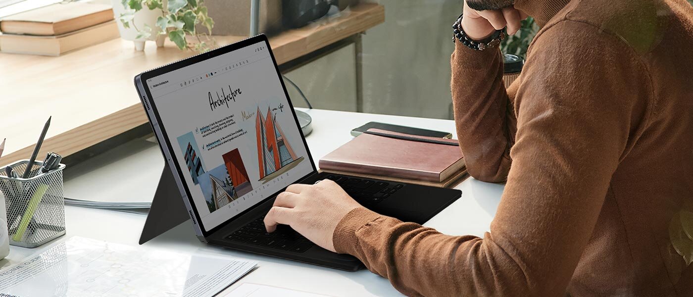 Mężczyzna korzysta z Galaxy Tab S10, trzymając dłoń na etui Book Cover Keyboard. Mężczyzna korzysta z Galaxy Tab S10, trzymając dłoń na etui Book Cover Keyboard.