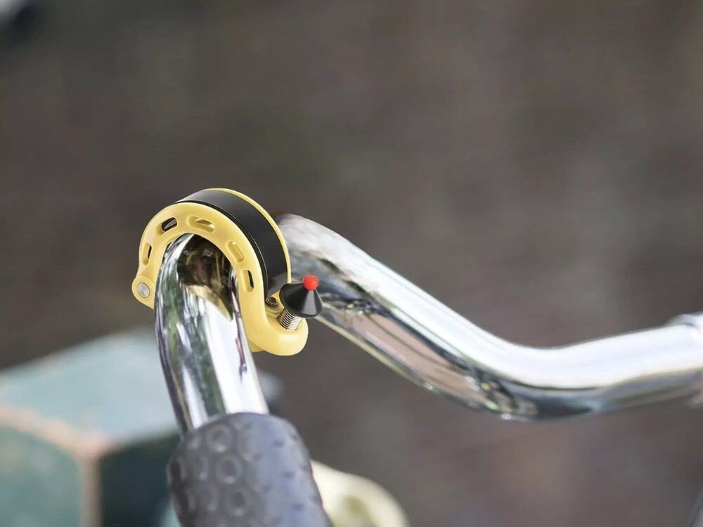 Dzwonek rowerowy ROCKBROS 34210028004 Żółty, Ergonomiczna, kształt, dopasowanie, funkcjonalność, Dzwonek zamontowany na srebrnej kierownicy roweru.