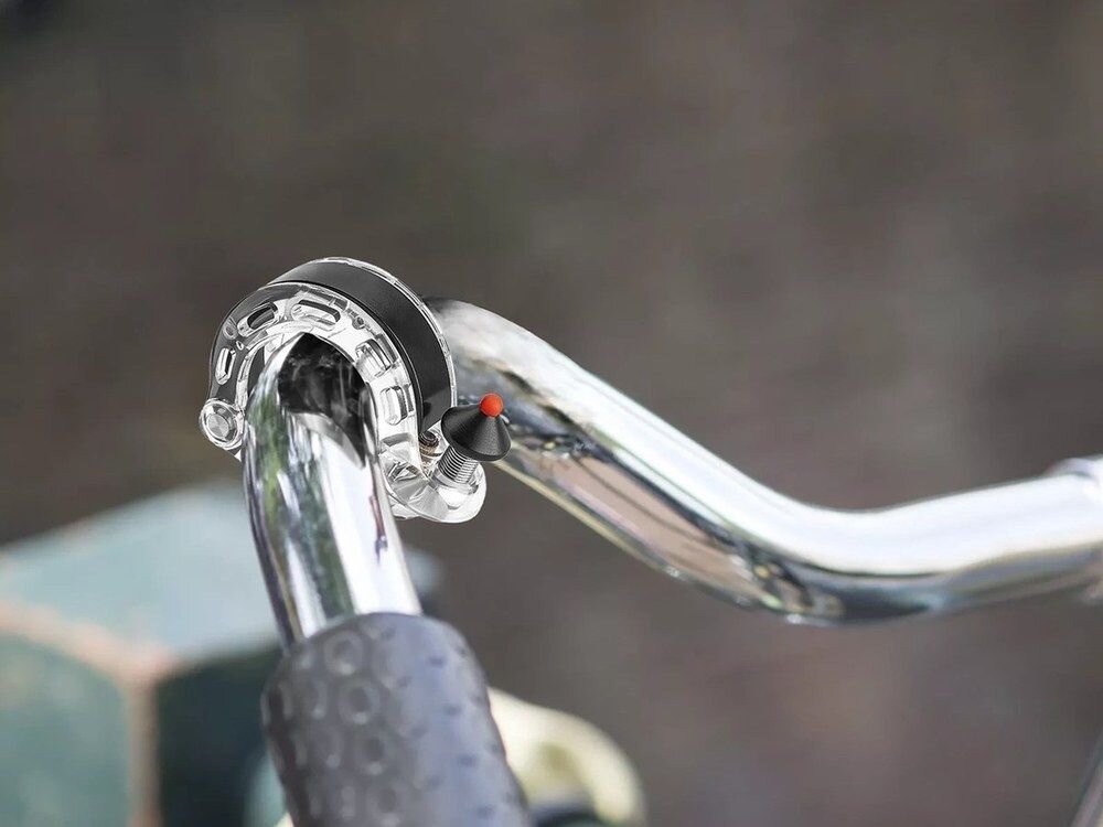 Dzwonek rowerowy ROCKBROS 34210028002 Przezroczysty, Ergonomiczna, kształt, dopasowanie, funkcjonalność, Dzwonek zamontowany na srebrnej kierownicy roweru.