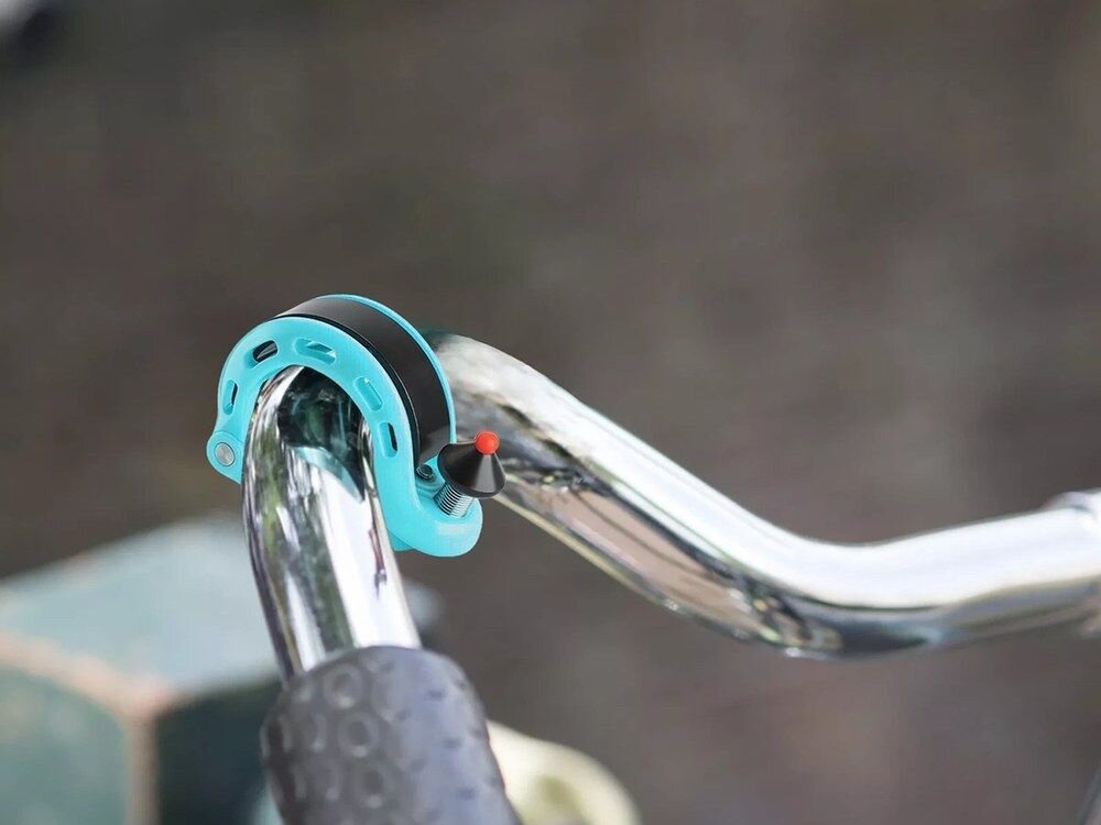 Dzwonek rowerowy ROCKBROS 34210028003 Niebieski, Ergonomiczna, kształt, dopasowanie, funkcjonalność, Dzwonek zamontowany na srebrnej kierownicy roweru.