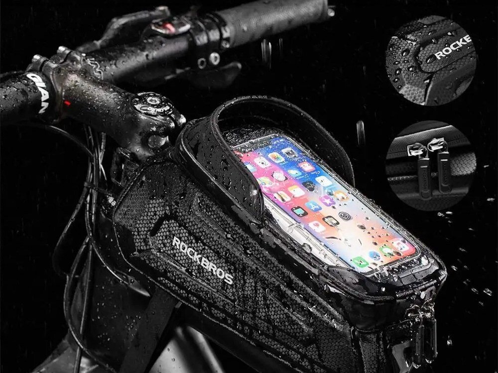 Na zdjęciu widoczna jest torba rowerowa na ramę z logo ROCKBROS, zamontowana na rowerze, pokryta kroplami wody. W torbie znajduje się telefon z widocznym ekranem, a obok pokazane są zbliżenia na zamek i logo.