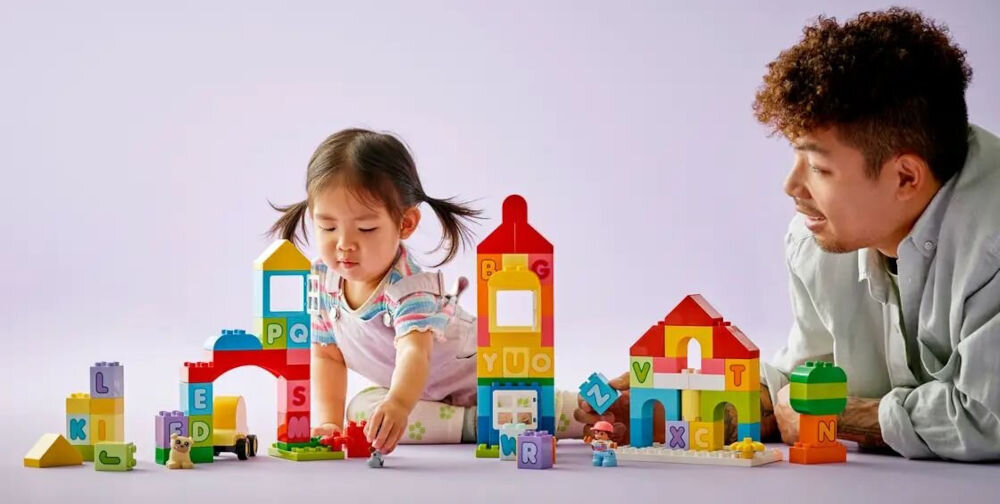 LEGO 10935 DUPLO Alfabetowe miasto zbuduj własne miasto dziewczynka bawiąca się klockami pod opieką starszej osoby