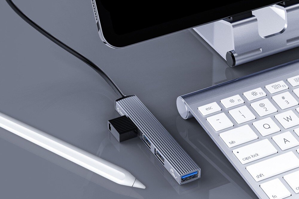 Hub ORICO AH-13-GY-EP-HW Adapter USB-C z podłączonymi akcesoriami leży na biurku obok białej klawiatury, tabletu i rysika, tablety, smartfony, funkcje, obsługa