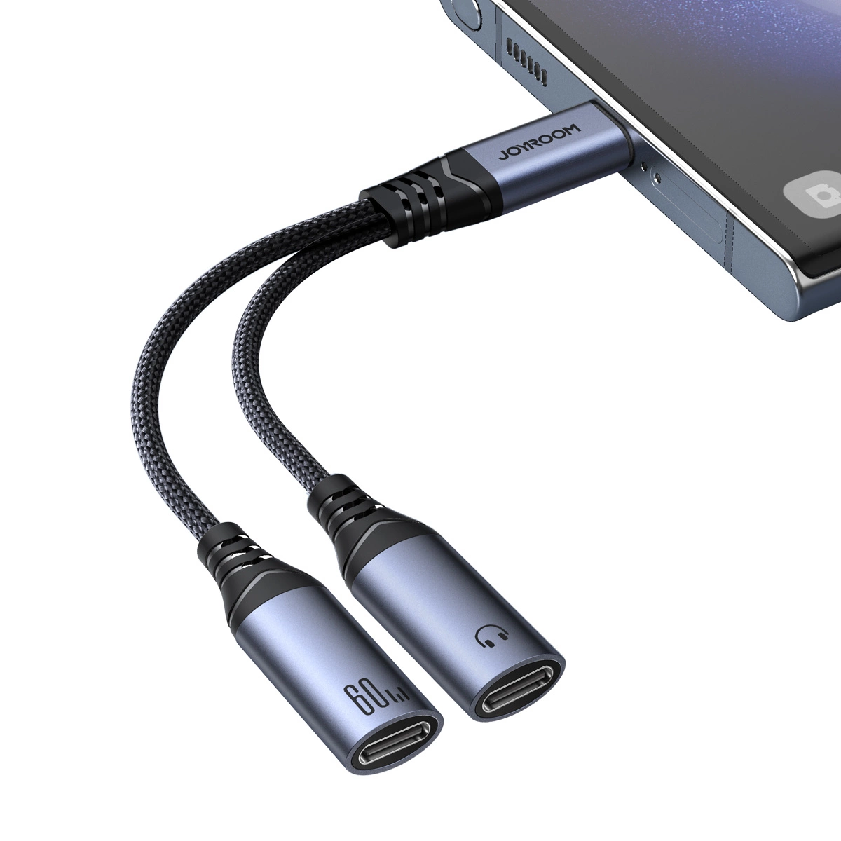 Na obrazie widoczny jest adapter z dwoma przewodami zakończonymi złączami USB-C, podłączony do urządzenia. Na adapterze znajduje się napis \'JOYROOM\' oraz symbole \'60W\' i słuchawki.
