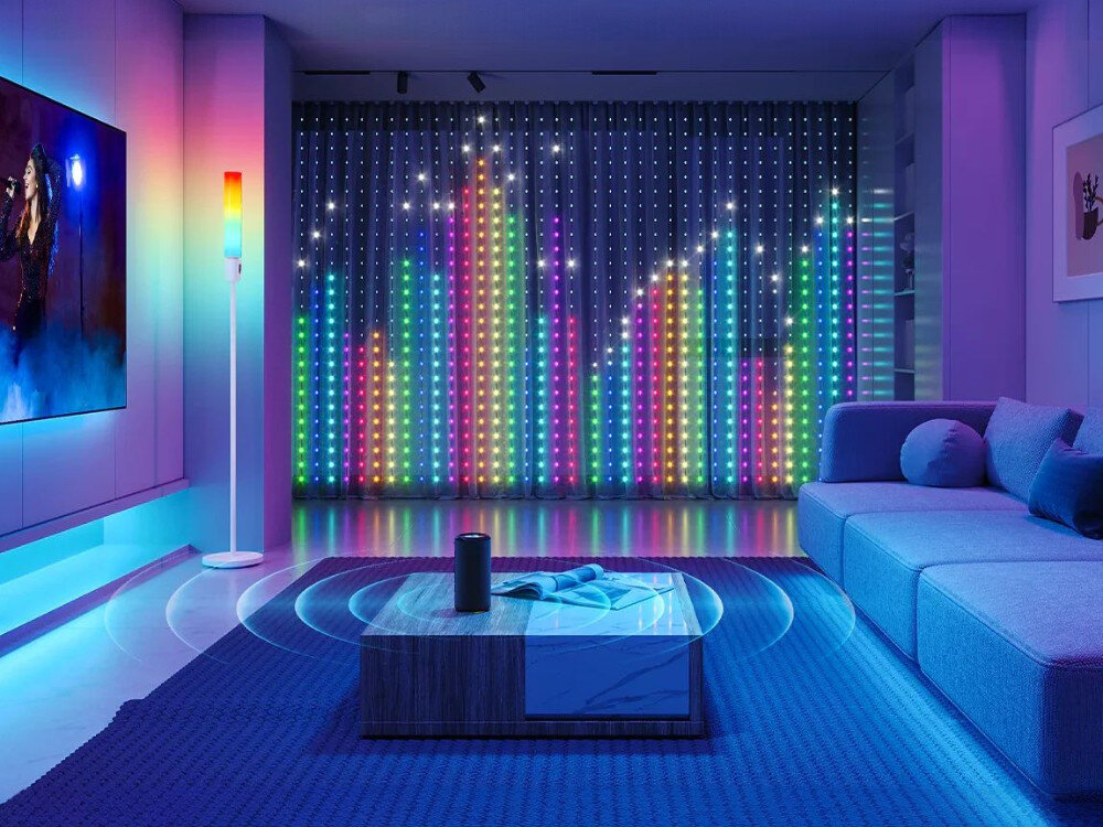 Kurtyna dekoracyjna GOVEE H70BC 400 LED Sieciowe 1.5 m Sieciowe Transparentny, sterowanie, głos, aplikacja, komfort, salon z dużą kurtyną LED tworzącą kolorowy wizualizator muzyki na ścianie za sofą i stolikiem kawowym.