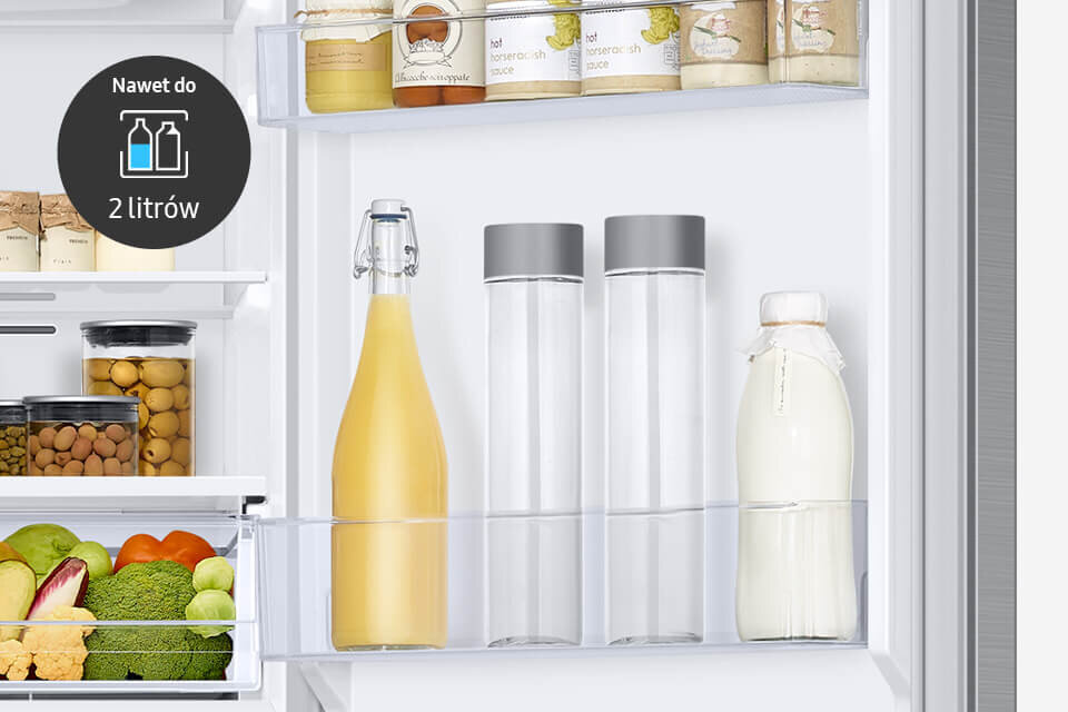 Wnętrze lodówki z półkami wypełnionymi różnymi produktami spożywczymi, w tym butelkami z napojami i słoikami. Na obrazie widoczny jest tekst: \'Nawet do 2 litrów\'.