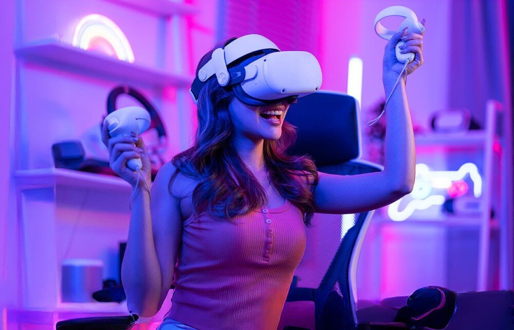 Płyta główna ASROCK X870E TAICHI Lite Osoba w zestawie VR siedząca na krześle i trzymająca kontrolery w kolorowym świetle pomieszczenia, łączność, Wi-Fi, Bluetooth