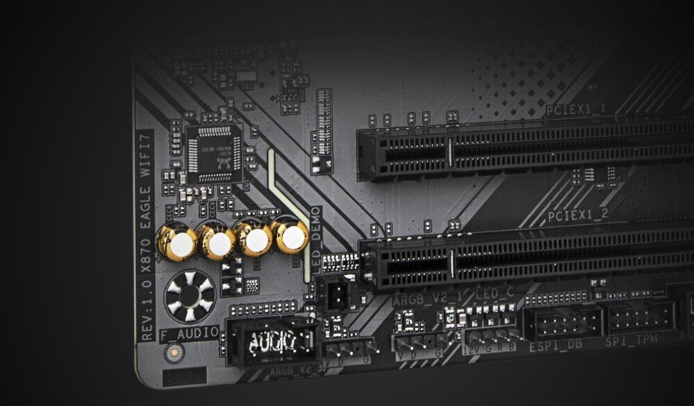 Płyta główna GIGABYTE X870 Eagle WiFi7 Zbliżenie na fragment układu audio na płycie głównej ze złotymi kondensatorami i czarnymi slotami PCIe, układ audio, podświetlenie, aplikacja