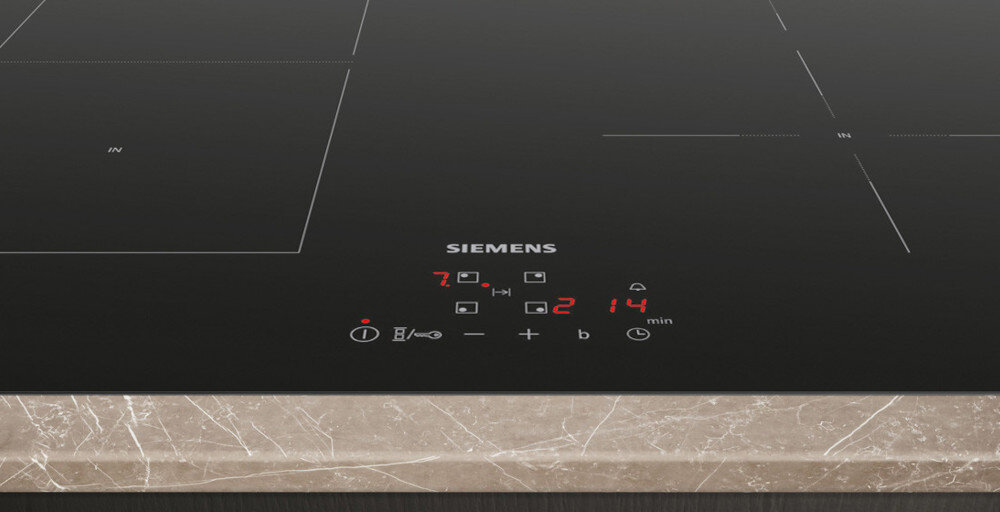 PŁYTA SIEMENS EE611BPB5E Na zdjęciu widoczny jest zbliżony fragment płyty indukcyjnej Siemens z centralnie umieszczonym, czerwonym panelem dotykowym. Cyfrowe wskaźniki mocy i minutnika oraz ikony funkcji tworzą czytelny interfejs sterowania na gładkiej, czarnej powierzchni szkła touchControl precyzyjna kontrola strefy grzania szybkie gotowanie intuicyjny panel elegancki komfort estetyka