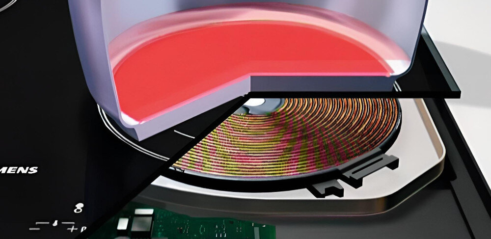 PŁYTA SIEMENS EE611BPB5E Na ilustracji przedstawiono przekrojony fragment płyty indukcyjnej Siemens: na górze widoczny jest podgrzewany garnek z rozgrzanym na czerwono dnem, a pod nim cewka indukcyjna i elementy elektroniki. Obraz pokazuje działanie pola grzewczego, w którym energia przekazywana jest bezpośrednio do naczynia poprzez pole elektromagnetyczne powerInduction 