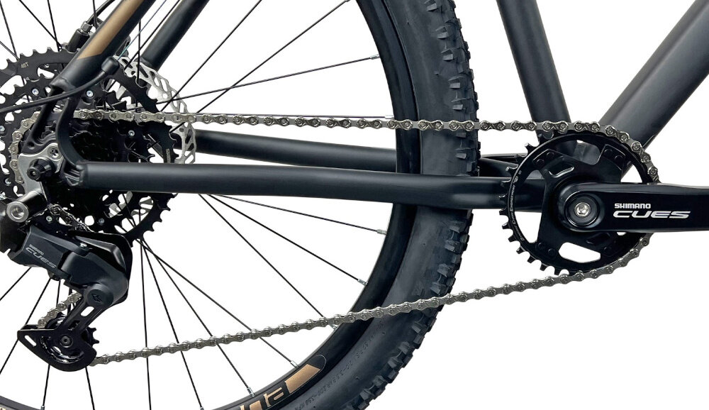 Rower górski MTB INDIANA X-Pulser 3.7 M17 27.5 cala męski Czarno-brązowy zbliżenie na korbę kasetę i łańcuch lekka wydajna konstrukcja korby korba SHIMANO CUES typu FC-U4000-1 kaseta SHIMANO CUES typu CS-LG-300 9V 11-46T solidność wytrzyma bardzo duży nacisk na pedały