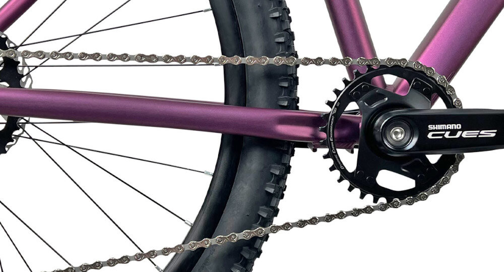 Rower górski MTB INDIANA X-Pulser 3.7 D19 27.5 cala damski Fioletowy zbliżenie na korbę kasetę i łańcuch lekka wydajna konstrukcja korby korba SHIMANO CUES typu FC-U4000 9SP kaseta SHIMANO CUES typu CS-LG-300  9speed 11-46T solidność wytrzyma bardzo duży nacisk na pedały