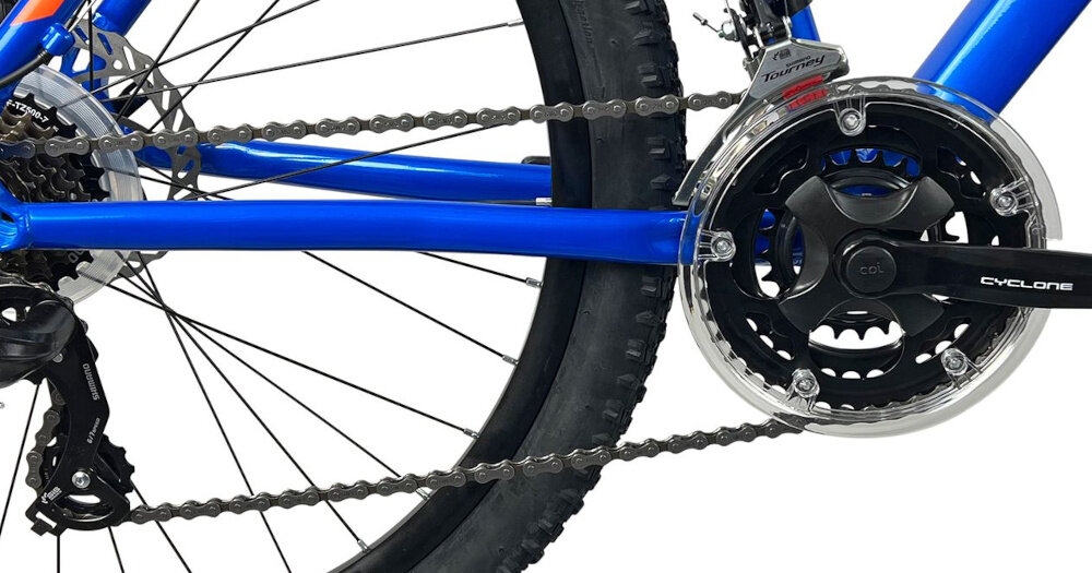 Rower górski MTB INDIANA X-Pulser 2.7 M17 27.5 cala męski Niebiesko-pomarańczowy zbliżenie na korbę wolnobieg i łańcuch lekka wydajna konstrukcja korby korba CYCLONE typu CTL-3 24/34/42T wolnobieg SHIMANO typu TZ-500 14-28 7 Speed solidność wytrzyma bardzo duży nacisk na pedały