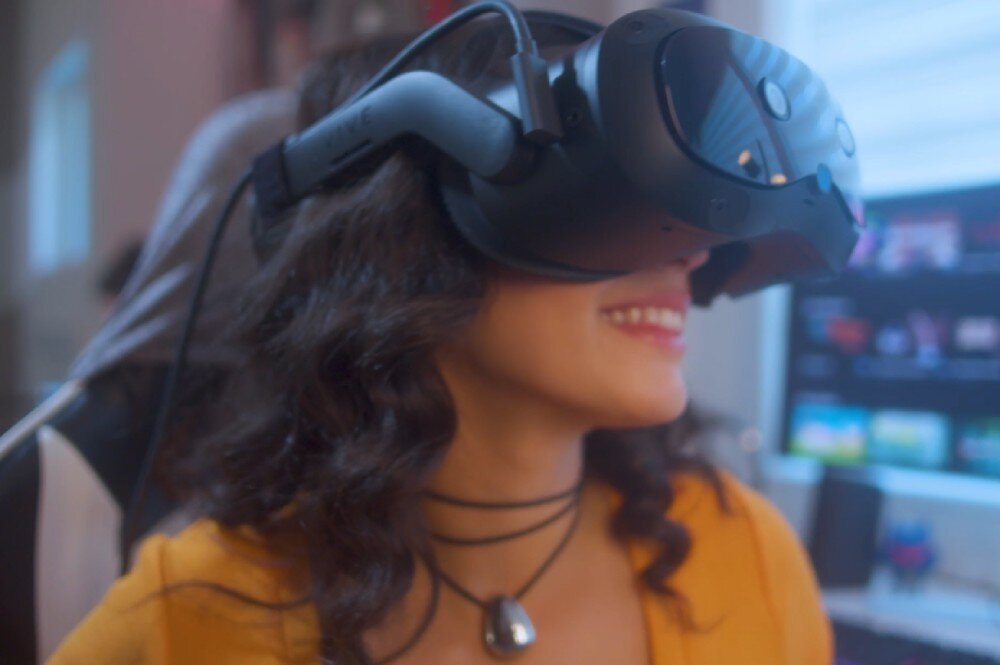Gogle VR HTC Vive Focus Vision osoba nosząca gogle podłączone przewodem do komputera łączność DisplayPort Wi-Fi