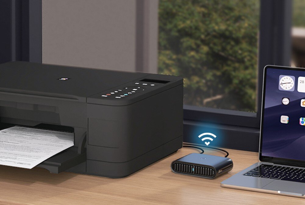 Router TP-LINK TL-WR1502X Czarny router stoi na biurku obok laptopa i drukarki. Od urządzenia rozchodzi się symbol połączenia Wi-Fi, funkcje, zabezpieczenia, konfiguracja