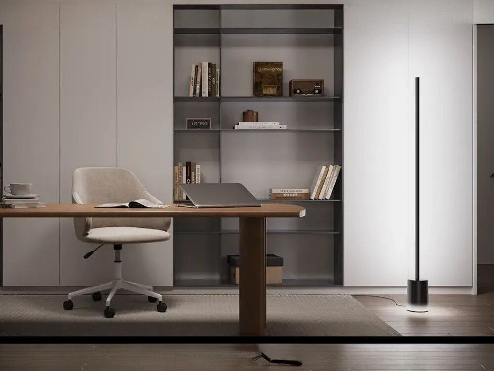Lampa podłogowa GOVEE H607C, RGBICWW, kolory, temperatura, jasność, Nowoczesne biurko z laptopem, kubkiem kawy i książkami w minimalistycznym gabinecie z szafkami, oświetlone białym światłem (ok. 4000K) od wysokiej czarnej lampy podłogowej Govee RGBIC, podkreślającej ergonomiczne krzesło i regały z dekoracjami.