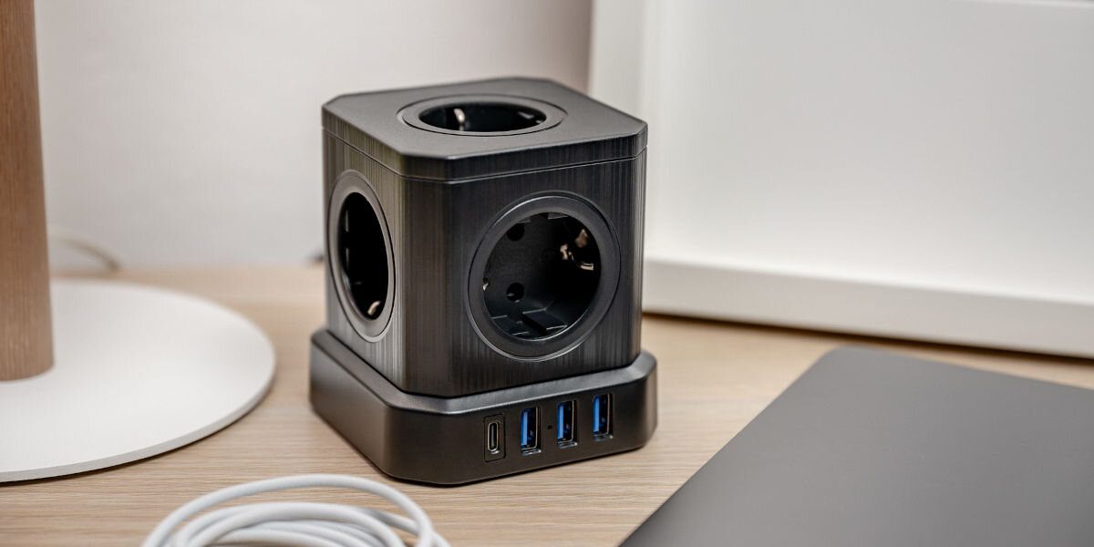 Listwa NEWELL GaN Power Cube NL4387 Czarny, kostka, newell, energia, komfort, kostka stoi na blacie wśród mebli