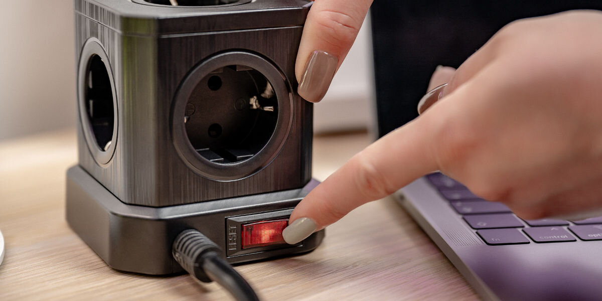 Listwa NEWELL GaN Power Cube NL4387 Czarny, obudowa, ochrona, przepięcie, trwałość, palec dłoni przyciska wyłącznik kostki