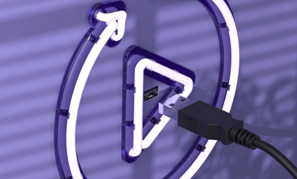 Obraz przedstawia fioletowy neonowy symbol z wtyczką USB podłączoną do portu. Tło jest w odcieniach fioletu z widocznymi cieniami.