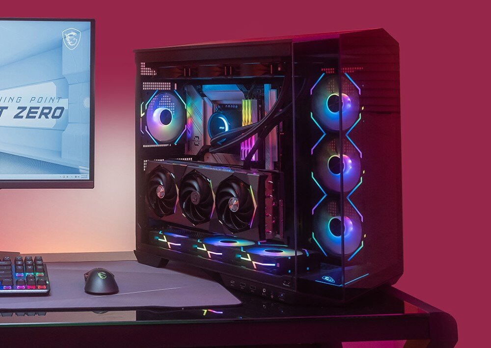 Obudowa MSI MAG Pano 100R PZ Obudowa komputerowa z pełnym wyposażeniem ustawiona na biurku w ciemnym pomieszczeniu, z widoczną kartą graficzną zamontowaną równolegle do płyty głównej oraz podświetleniem ARGB