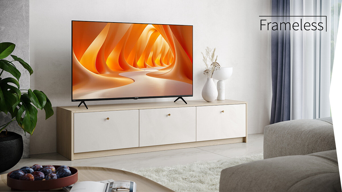 Telewizor SHARP 55GK4245E smukły design, bezramkowa konstrukcja, elegancki wygląd, minimalistyczny styl, telewizor stojący na komodzie w pomieszczeniu