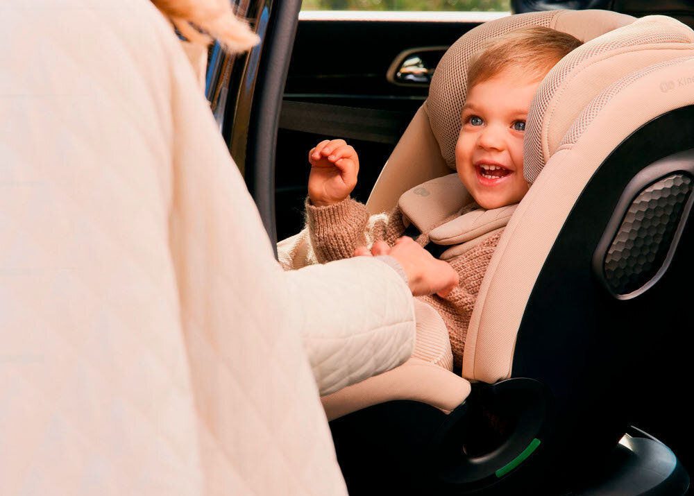 Fotelik samochodowy KINDERKRAFT Xpedition 3 I-Size 40-150 cm (0-22 kg) Beżowy wnętrze samochodu dziecko siedzi w foteliku bezpieczeństwo jazda samochodem fotelik na lata