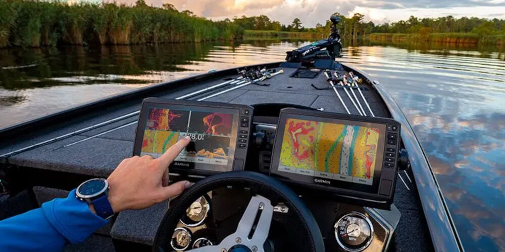 Echosonda wędkarska GARMIN LiveScope Plus z modułem GLS 10 i przetwornikiem LVS34 osoba na łódce płynie po wodzie dotyka palcami echosondy funkcje Forward Down i Perspective dostosowanie widoku do aktualnych potrzeb skuteczność połowu