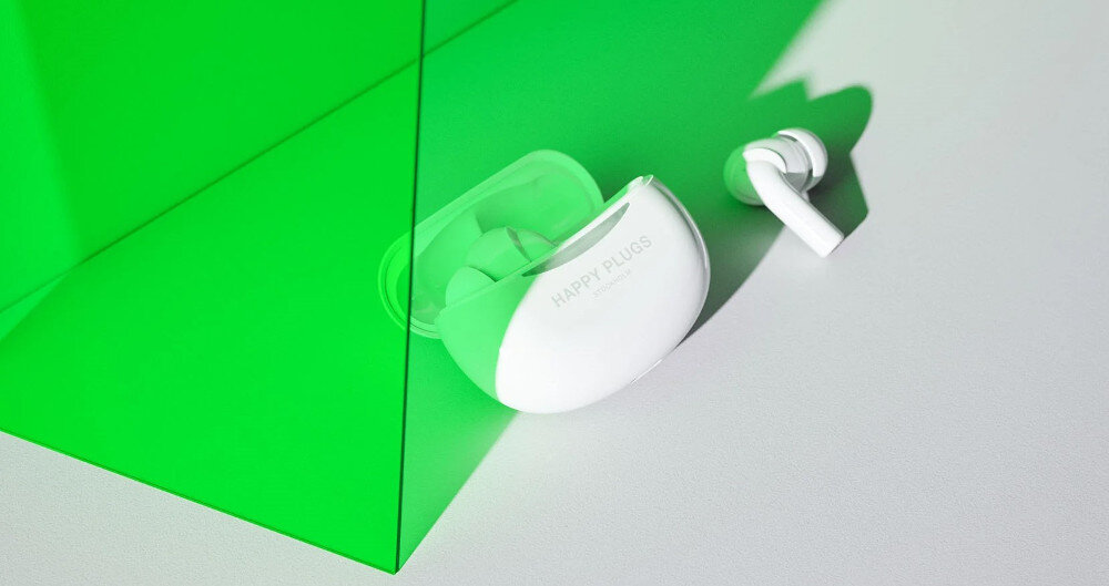 Słuchawki dokanałowe HAPPY PLUGS Joy Pro - Słuchaj bez przerwy, słuchawki z etui ładującym na białym blacie