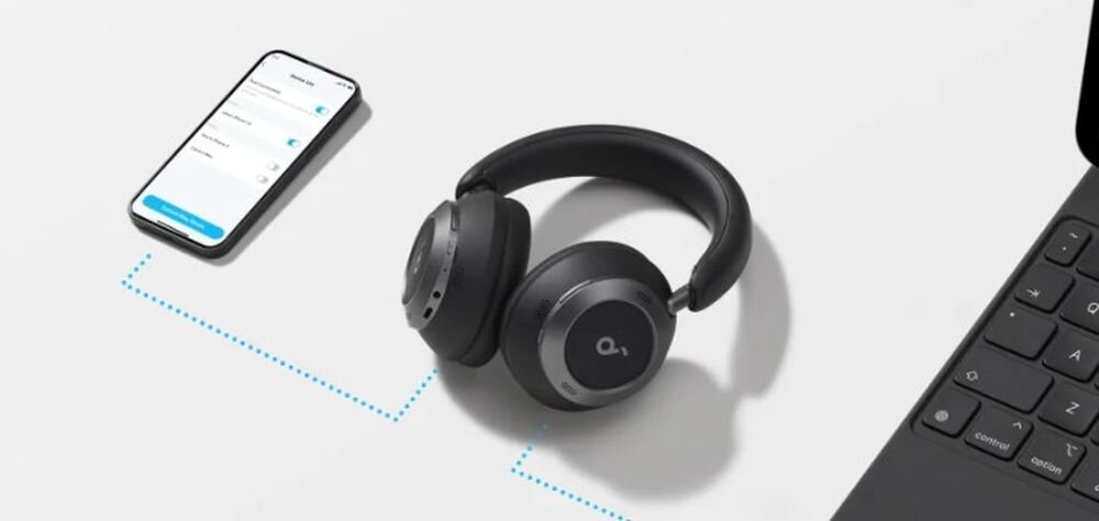 SOUNDCORE Space One Pro ANC Bluetooth 5.3 multipoint Fast Pair Android połączenie stabilność, słuchawki nauszne leżące na białym blacie obok smartfona oraz laptopa