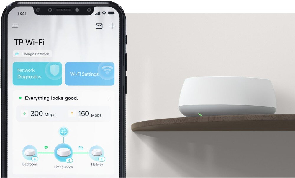 Router TP-LINK Deco BE25 Zdjęcie ekranu smartfona przedstawiającego interfejs aplikacji do zarządzania siecią Wi-Fi. Obok telefonem na półce stoi router, aplikacja, konfiguracja, komendy głosowe
