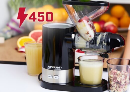 Wyciskarka wolnoobrotowa podczas pracy. Świeże owoce w podajniku, sok spływający do szklanki. Oznaczenie mocy 450 W.