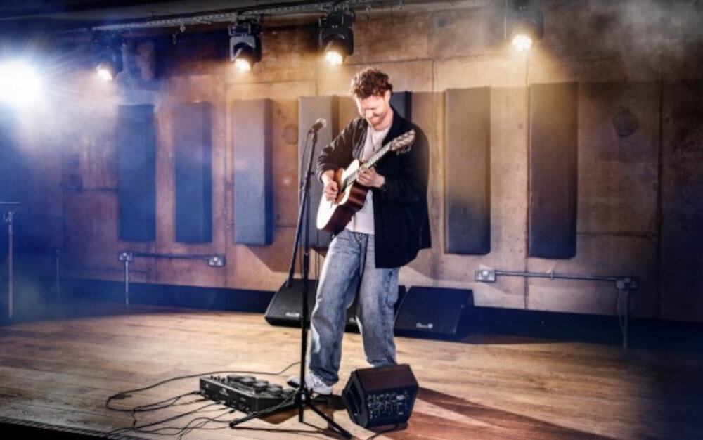 Looper HEADRUSH Sheeran Looper X - Silnik efektów, osoba grająca na gitarze na scenie