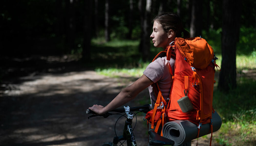 Głośnik mobilny MOTOROLA ROKR 300 - Muzyka, gdzie chcesz, osoba jadąca na rowerze z plecakiem podróżnym, do plecaka przyczepiony głośnik mobilny