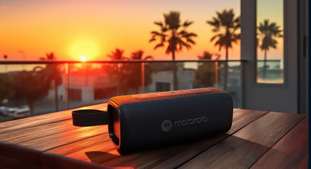 Głośnik mobilny MOTOROLA ROKR 600 - Słuchaj przez cały dzień, głośnik położony na stoliku o zachodzie słońca