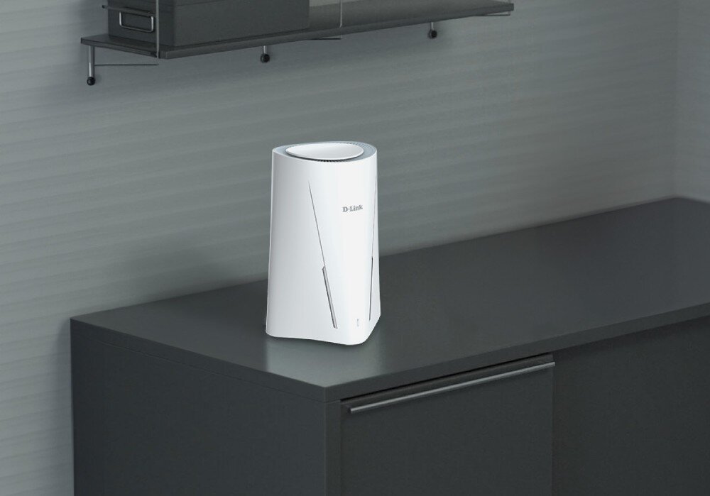 Router D-LINK G530 Białe urządzenie sieciowe stojące na ciemnym blacie szafki w minimalistycznym wnętrzu