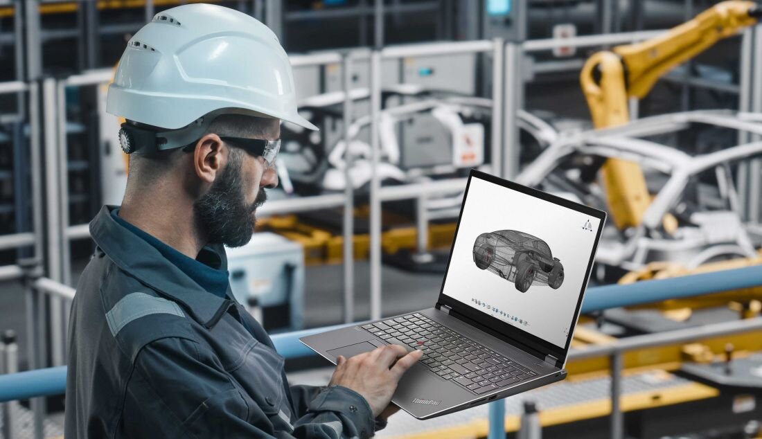 Inżynier w kasku pracujący na laptopie Lenovo ThinkPad P16 w hali produkcyjnej, widoczny model 3D samochodu na ekranie - SSD PCIe NVMe 4.0 x4
