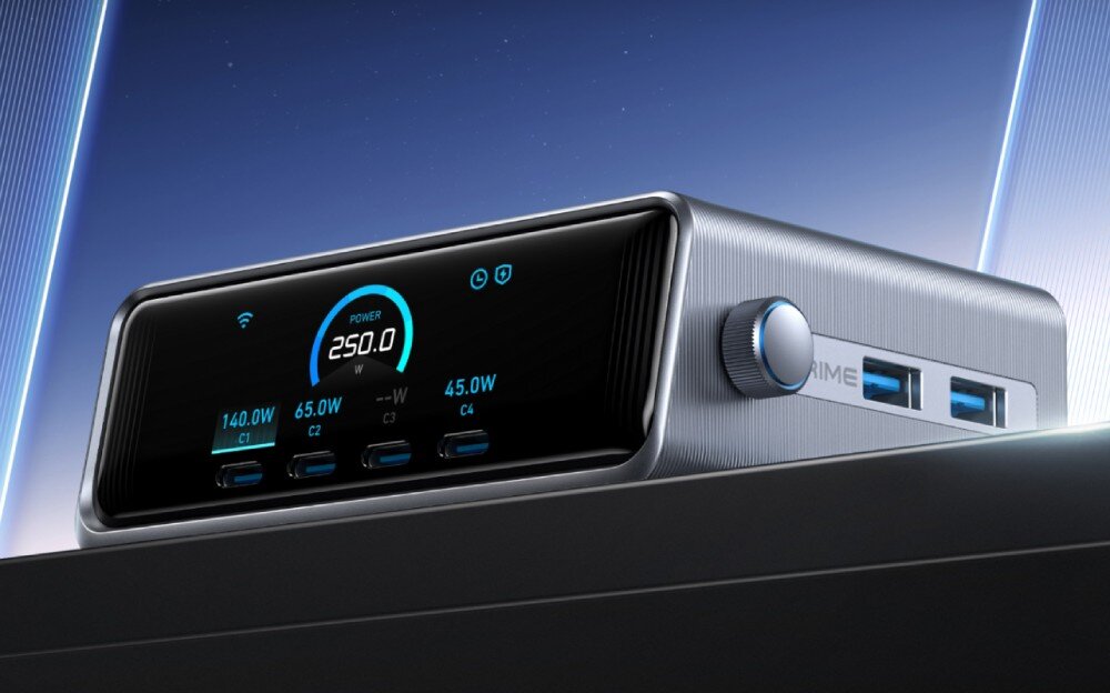 Zasilacz do laptopa ANKER Prime GaN 250W Srebrna stacja ładująca z dużym kolorowym wyświetlaczem z przodu, który pokazuje całkowitą moc 250W oraz rozkład mocy na cztery porty USB-C, obok których znajdują się dwa porty USB-A i pokrętło sterujące na bocznej ściance