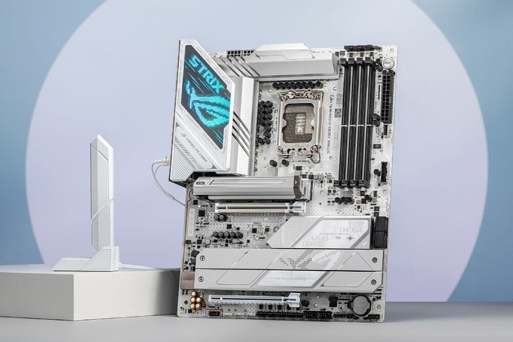 Płyta główna ASUS ROG Strix Z890-A Gaming WiFi Płyta główna w białej kolorystyce stojąca pionowo obok zewnętrznej anteny Wi-Fi na tle jasnoniebieskiego koła, wygląd, obudowa, styl