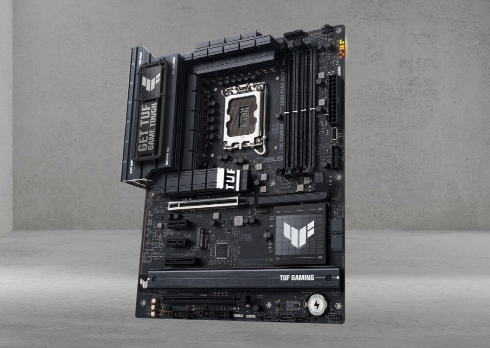 Płyta główna ASUS TUF Gaming Z890-PLUS WiFi Ujęcie stojącej płyty na szarym tle z dużymi radiatorami, czterema slotami pamięci i osłoną chipsetu z logo, pamięć RAM, taktowanie