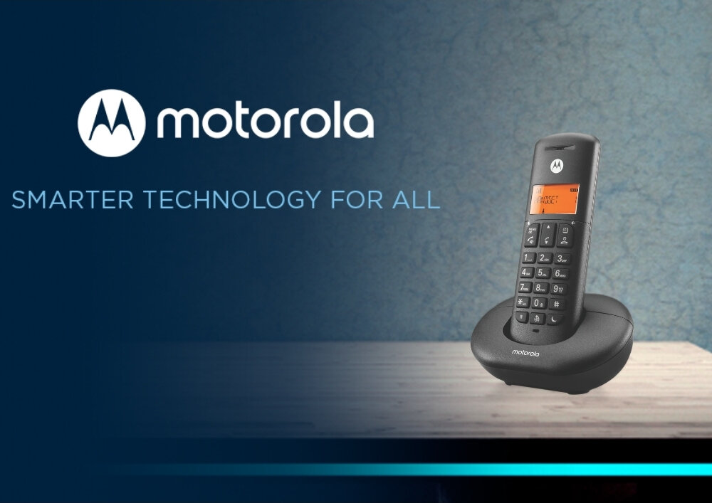 Na obrazie widoczny jest czarny telefon bezprzewodowy z wyświetlaczem umieszczony na stacji dokującej. Obok znajduje się logo \'motorola\' oraz napis \'SMARTER TECHNOLOGY FOR ALL\'.