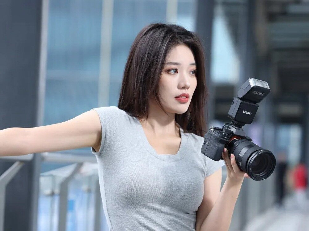 Lampa błyskowa Ulanzi F32 na aparacie, trzymana przez modelkę