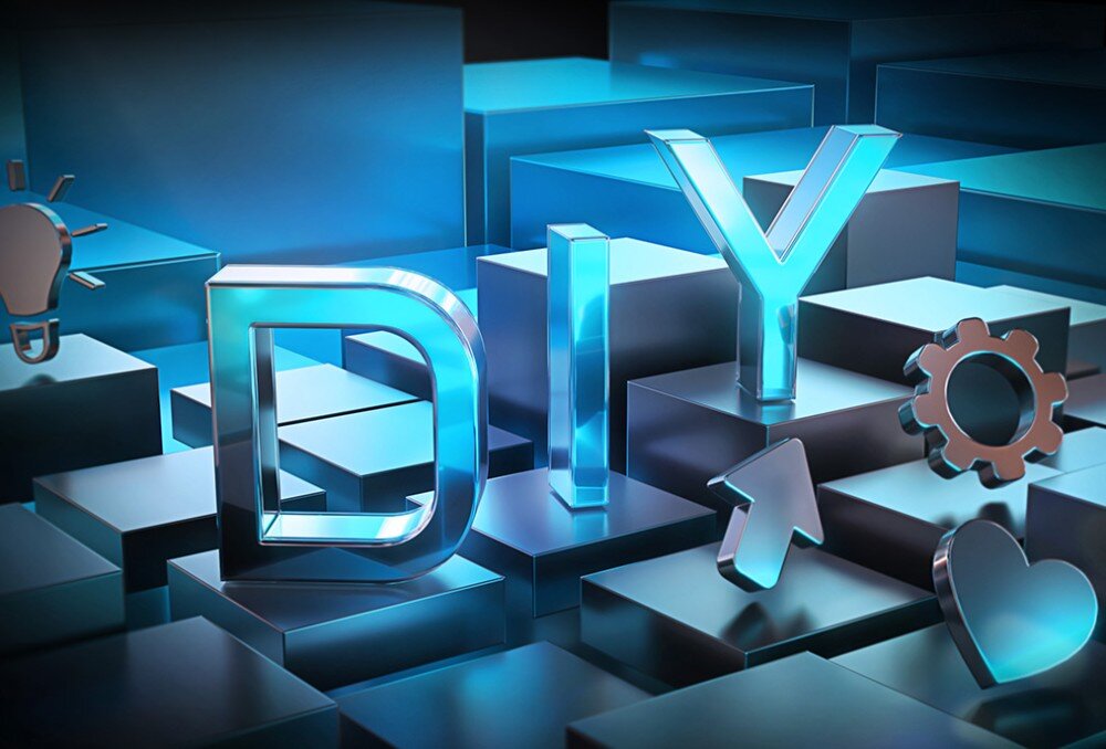 Płyta główna GIGABYTE Z890M Gaming X Trójwymiarowy błękitny napis 'DIY' w otoczeniu lewitujących ikon żarówki, koła zębatego i serca na metalicznych blokach